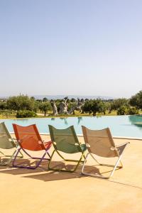 three lawn chairs sitting in front of a pool at Agua Green Resort in San Lorenzo