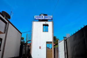 a white building with a sign on top of it at Habermotel Enterprises Ltd in Entebbe