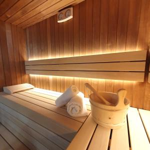 a sauna with towels and a basket on a table at Hotel Alpha Paris Eiffel by Patrick Hayat in Boulogne-Billancourt