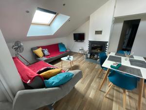 a living room with a couch and a table at Appart’ terrasse vue exceptionnelle 1er étage in Montbéliard