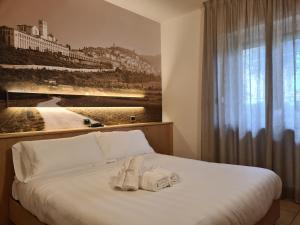a bedroom with a bed with towels on it at Hotel Cladan in Assisi