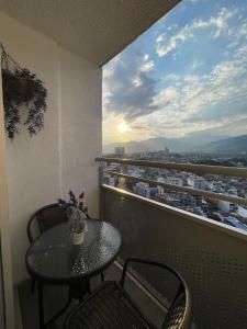a table and chairs on a balcony with a view of a city at apto piedra pintada alta in Vallecito
