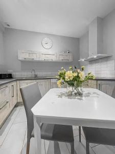 a kitchen with a table with a vase of flowers on it at Le Cocon d'Availles en Chatellerault in Availles en Chatellerault