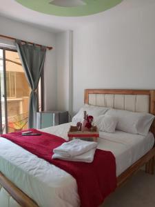 a bed with a red blanket and a teddy bear on it at Dreimar Hotel Boutique in Cartagena de Indias