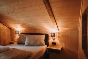 1 dormitorio con 1 cama en una habitación de madera en Oberwald Chalets Ferienhaus 2, en Breungeshain