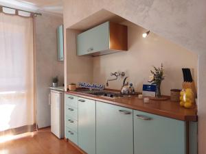 a kitchen with white cabinets and a sink at House Fiocco di Neve by Holiday World in Limone Piemonte