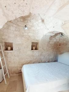 een slaapkamer met een bed in een stenen muur bij Trulli al Verde Viburno in Martina Franca