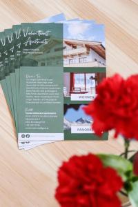 a brochure and a red flower on a table at Apartment Vordermitterast in Kirchberg in Tirol