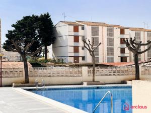 a swimming pool with trees in front of a building at Joya Mediterránea in Benicàssim