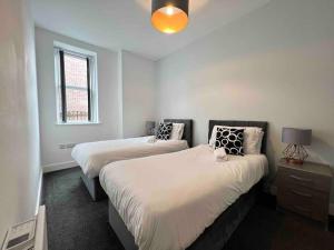 1 Schlafzimmer mit 2 Betten und einem Fenster in der Unterkunft FREE PARKING - Cosy 2-BR Flat near Salford Royal in Manchester