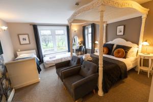 a bedroom with a canopy bed and a chair at Wyndgrove House in Seahouses