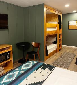 ein Schlafzimmer mit Etagenbetten, einem Tisch und einem Stuhl in der Unterkunft Jackalope Motor Lodge in Pinedale