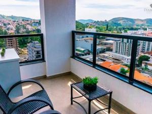 a balcony with two chairs and a table and a view at Diamond Hotéis e Flats in São Lourenço