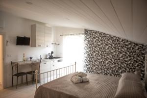 a bedroom with a bed and a table and a kitchen at Sweet in Gragnano