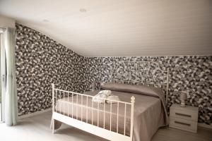 a bedroom with a bed and a wall covered in logs at Sweet in Gragnano