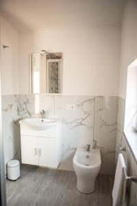 a white bathroom with a sink and a toilet at Sweet in Gragnano