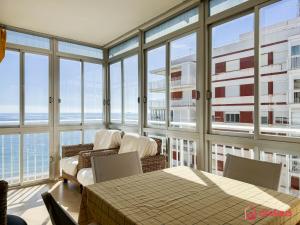 a living room with a couch and tables and windows at Joya Mediterránea in Benicàssim