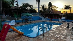 a swimming pool with a slide in a resort at Pousada das Cores in Olímpia
