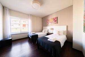 Habitación de hotel con 2 camas y ventana en Luxury Apartments Baleal, en Baleal