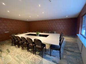 einen Konferenzraum mit einem weißen Tisch und Stühlen in der Unterkunft Hotel Rheinstein in Rüdesheim am Rhein