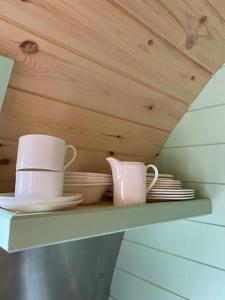 une étagère avec deux tasses et des assiettes dans l'établissement Beautiful Seaview Lodge overlooking Loch Linnhe, à Fort William