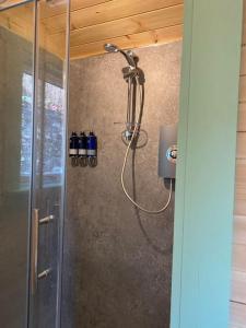 a shower with a glass door in a bathroom at Beautiful Seaview Lodge overlooking Loch Linnhe in Fort William
