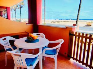 una mesa con sillas y un bol de fruta en ella en Casita La Caleta Fuerteventura, en Parque Holandes