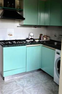 a kitchen with blue cabinets and a washing machine at Casa MaLù in Ladispoli