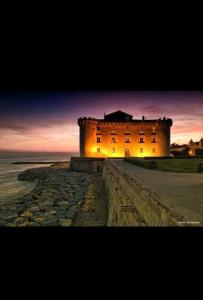 a castle sitting on top of the ocean at sunset at Casa MaLù in Ladispoli