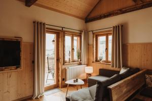 a living room with a couch and a tv at Oberwald Chalets Ferienhaus 4 in Breungeshain