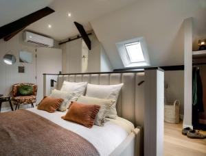 een slaapkamer met een bed met kussens en een raam bij Maria Hoeve Hoornaar in Hoornaar