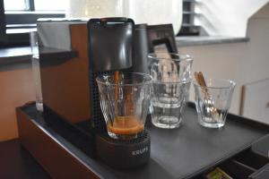 een koffiezetapparaat en twee glazen op een aanrecht bij Maria Hoeve Hoornaar in Hoornaar