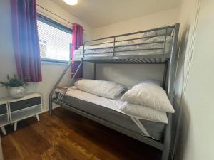 a bedroom with a bunk bed with pillows on it at The Green One, Sunbeach, Scratby - Two bed chalet, sleeps 5, free Wi-Fi, pet friendly, bed linen and towels included plus free entry to onsite clubhouse in Scratby