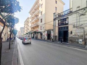 ein Auto, das eine Stadtstraße mit Gebäuden entlangfährt in der Unterkunft [Centro città - Wifi & Cucina] Posizione ottimale in Salerno
