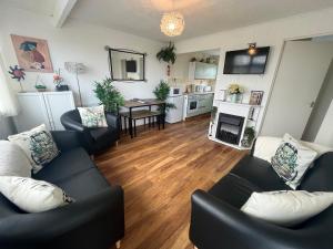 a living room with two couches and a table at The Green One, Sunbeach, Scratby - Two bed chalet, sleeps 5, free Wi-Fi, pet friendly, bed linen and towels included plus free entry to onsite clubhouse in Scratby