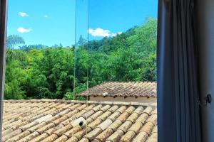 uma vista para um telhado de azulejos de uma casa em Flat 131 - Point do Canto em Rio Acima