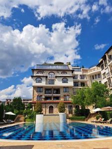 um grande edifício com uma piscina em frente em Апартамент VIP комплекс ARTUR em Sveti Vlas
