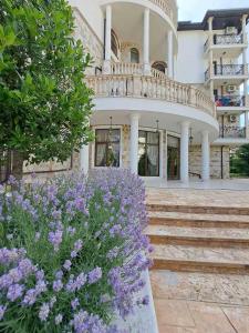 un edificio con balcón y flores púrpuras en Апартамент VIP комплекс ARTUR en Sveti Vlas