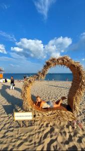 a woman laying in a straw basket on a beach at Апартамент VESI комплекс ARTUR in Sveti Vlas