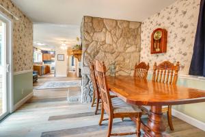 a dining room with a stone wall and a wooden table and chairs at Wilmington Getaway Near Carolina Beach Boardwalk! in Wilmington