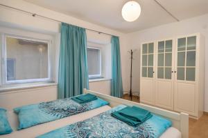 2 łóżka w sypialni z zielonymi zasłonami w obiekcie Ferienwohnungen Spiegel Felsgässele w mieście Lindau