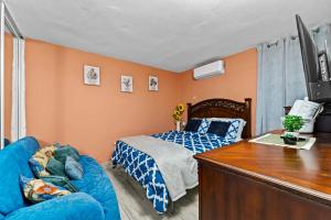 a bedroom with a bed and a blue couch at Lupa Guesthouse affordable family home in Rincon