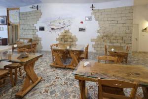 una stanza con tavoli e sedie in legno e una parete di Antico Borgo Marchese a Morciano di Leuca