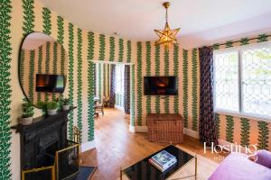 uma sala de estar com paredes com riscas verdes e brancas em Luxurious Vineyard Hideaway At Stanlake Park em Wokingham