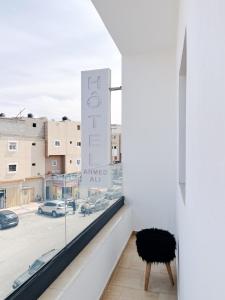 Cette chambre est dotée d'une fenêtre avec un panneau indiquant des œuvres d'art égoïstes. dans l'établissement Hotel Ahmed Ali, à Dakhla