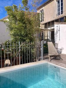 a swimming pool in front of a house at Hôtel Le Sénéchal in Ars-en-Ré