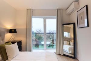 um quarto com uma cama e um espelho em The Wembley Park Arms - Modern 2BDR Flat with Parking + Balcony em Londres