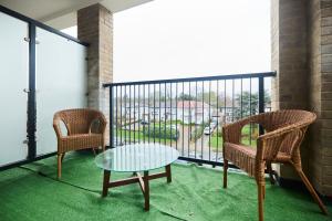 a balcony with two chairs and a glass table at The Wembley Park Arms - Modern 2BDR Flat with Parking + Balcony in London