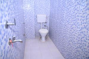 baño con aseo en una pared de azulejos azules en Hotel Mahamaya Guest House Varanasi en Varanasi