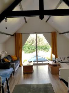 ein Wohnzimmer mit einem Sofa und einem großen Fenster in der Unterkunft T2 calme et chaleureux 1 à 5 pers in Alençon